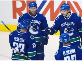 Vancouver Canucks’ Radim Vrbata, of the Czech Republic, clockwise from top right, Daniel Sedin and Henrik Sedin, of Sweden, and Ryan Stanton celebrate a pre-season goal. Vrbata was clicking with the Sedin twins on Wednesday night.