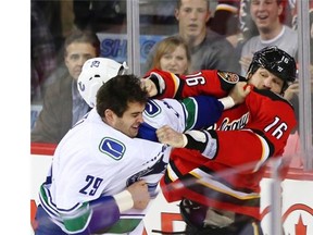 Vancouver Canucks tough guy Tom Sestito and Calgary Flames bruiser Brian McGrattan square off during a game last season at the Saddledome. The Flames are helping their players protect themselves by using a fighting coach.