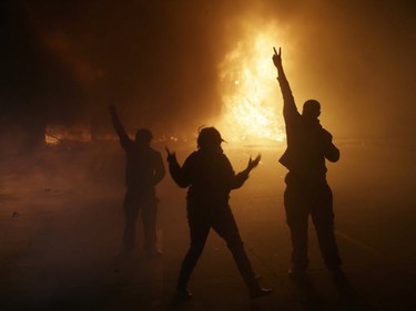 Police officers in riot gear stand in front of a burning building during a protest on November 24, 2014 in Ferguson, Missouri. A St. Louis County grand jury has decided to not indict Ferguson police Officer Darren Wilson in the shooting of Michael Brown that sparked riots in Ferguson, Missouri in August.