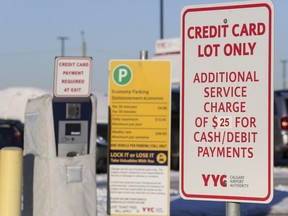 Signs from the Calgary Airport Authority warns drivers that paying for parking with debit or cash will result in a service fee of $25 in certain lots at the airport.