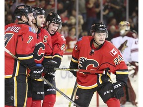 Calgary Flames' Captain Mark Giordano, second from left, celebrates with Tj Brodie, left, Sean Monahan, and Jiri Hudler, with Arizona goalie Mike Smith in the background, after he scores the Flames' fourth goal of the game to put them in the lead against the Arizona Coyotes after the second period at the Saddledome in Calgary, on November 13, 2014.