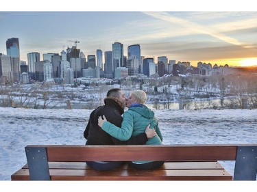 Vania Poletti, right, and Pierluigi Cesano, stop to watch the sunset over downtown Calgary and the mountains after arriving from Italy only hours earlier, on November 18, 2014.