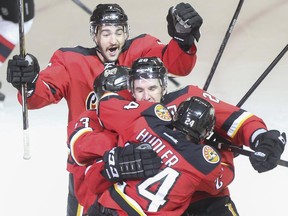 Crystal Schick/ Calgary Herald CALGARY, AB -- Calgary Flames Tj Brodie, back, Curtis Glencross, centre and Jiri Hudler celebrate a goal in the third period against the New Jersey Devils at the Scotiabank Saddledome in Calgary, on November 22, 2014. --  (Crystal Schick/Calgary Herald) (For Sports story by  TBA) 00056697A