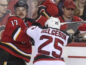 New Jersey Devil Seth Helgeson checks Calgary Flame Lance Bouma at the Saddledome on Saturday. Reader says a new arena would benefit Calgarians.