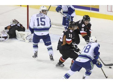 Calgary Hitmen goalie Mack Shields gets laid out by a Swift Current Bronco during Western Hockey League action at the Scotiabank Saddledome in Calgary, on November 28, 2014.