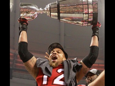 The Calgary Stampeders Juwan Simpson holds the Grey Cup after the team won the 2014 Grey Cup in Vancouver on Sunday November 30, 2014.