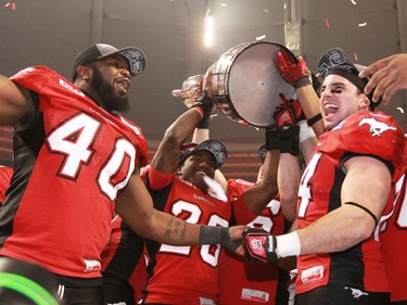 The Calgary Stampeders celebrate with the Grey Cup after the team won the 2014 Grey Cup in Vancouver on Sunday November 30, 2014.
(Gavin Young/Calgary Herald)
(For Sports section story by Rita Mingo, George Johnson) Trax# 00060714F