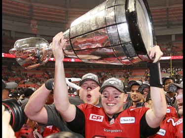 The Calgary Stampeders quarterback Bo Levi Mitchell holds the Grey Cup after the team won the 2014 Grey Cup in Vancouver on Sunday November 30, 2014.