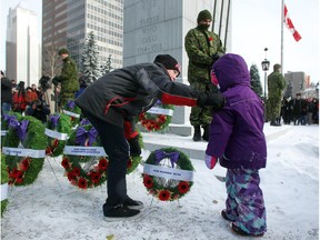 Riley Faschoway, 13, and his three-year-old cousin Emryss Agren laid a wreath for their great grandfather Calgary Higlander Ken Noonan at the base of the cenotaph as an honour guard stands in the background. Reader is glad that this year members of the honour guard dressed warmly at the Central Memorial Park monument during the Remembrance Day service.