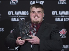 Brett Jones, of the Calgary Stampeders, celebrates his award for most outstanding offensive lineman during the CFL Awards in Vancouver, B.C. Thursday, Nov. 27, 2014.