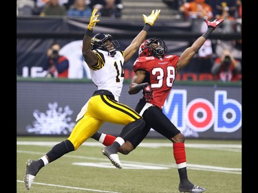 The Calgary Stampeders Buddy Jackson and the Ticats' Terrell Sinkfield reach for a pass during the 2014 Grey Cup in Vancouver on Sunday November 30, 2014.