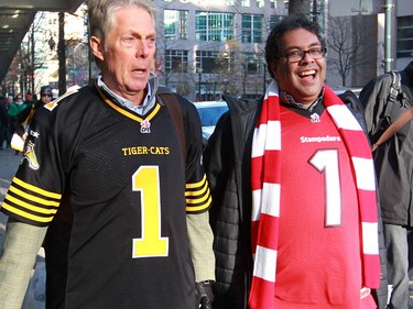 Hamilton Mayor Fred Eisenberger walks with Calgary Mayor Naheed Nenshi towards B.C. Place for the 2014 Grey Cup in Vancouver on Sunday November 30, 2014.