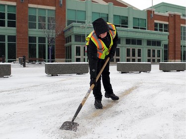Michael Berzins with the Calgary Stampede was trying to stay warm while clearing out the parking lines  while a light snow was falling and bitter cold temperatures blanketed the city of Calgary on November 28, 2014.