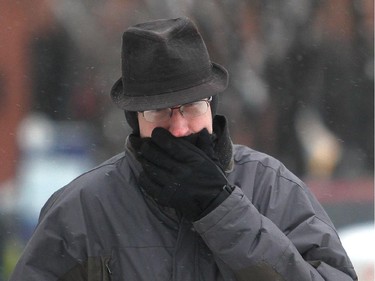 James Abbott clutches his scarf to his face walking  on 8th Street SW Friday morning November 28, 2014 as the wind chill hovered around minus 30 celcius.