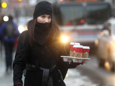Leah McInnis carries the providential tray of hot coffee for co-workers on her way into work on on 8th Street SW Friday morning November 28, 2014 as the wind chill hovered around minus 30 celcius.
