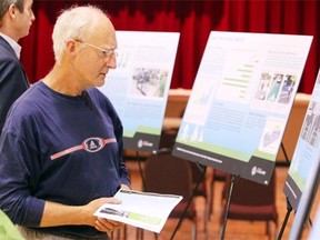 Calgary’s Alistair Des Moulins took a closer look at the billboards during a public open house about the Centre City Cycle Track Network Project on June 19, 2013.