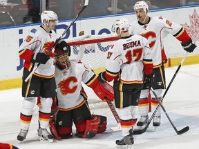 Goaltender Jonas Hiller #1 of the Calgary Flames is congratulated by teammates after the game against the Florida Panthers on November 8, 2014.