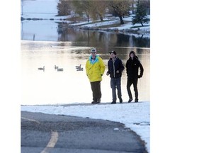 CALGARY, AB.; NOVEMBER 2 ,2014, --  From left, 
 Skyler Duiven, Randall Jones and  Daylan Duiven stroll along the shore of Harvest Hills Lake at sunset Sunday evening November 2, 2014. (Ted Rhodes/Calgary Herald) For City Standalone
