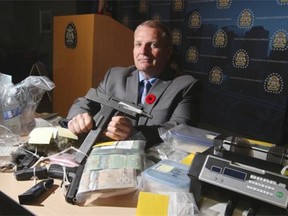 Calgary Police Service drug unit Staff Sgt. Tom Hanson poses with items seized during a drug operation that uncovered cocaine, marijuana, ecstasy and LSD -- to just name a few.
