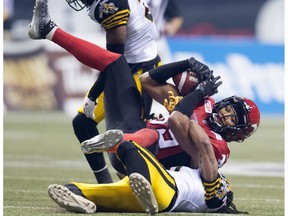 Calgary Stampeders' defensive back Fred Bennett takes the ball from Hamilton Tiger-Cats' linebacker Rico Murray during the 102nd Grey Cup in Vancouver, B.C. Sunday, Nov. 30, 2014.