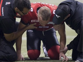 Calgary Stampeders punter Rob Maver is attended to after taking a hit during the 102nd Grey Cup against the Hamilton Tiger-Cats in Vancouver, B.C. Sunday, Nov. 30, 2014.