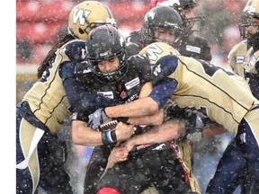 Calgary Stampeders receiver Anthony Parker is tackled by a host of Winnipeg Blue Bombers in the fourth quarter at McMahon Stadium on Saturday. The Stamps were on the losing end of their ugliest game of the season — an 18-13 loss to Winnipeg that wrecked their chance at a 16-win campaign.