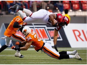 Calgary Stampeders slotback Nik Lewis, top, is upended by B.C. Lions’ Torri Williams during a preseason game at BC Place last June. The Stamps have struggled in the Vancouver stadium, without a win there in five years.