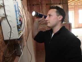 Home inspector James Manfron of Frontline Home Inspections scopes out the electrical panel in a Chestemere home.