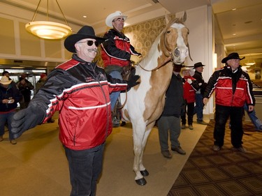 Dennis Nadeau, with members of the Calgary Grey Cup Committee, rides a quarterhorse into the Queen Elizabeth Hotel  in Montreal on the day before the 2008 Grey Cup.