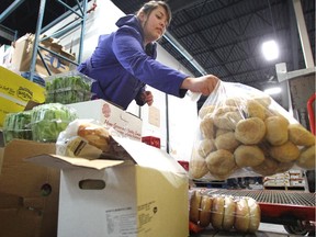 John Howard Society worker Brittany Ouellette gathers a cart full of food for the recipient agency at the Calgary Food Bank through the food link program.