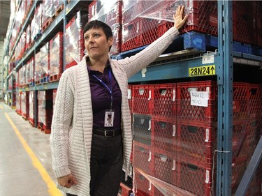 Calgary Food Bank Development Coordinator Keoma Duce stood with the emergency hampters of donated food at the food bank on November 13, 2014.