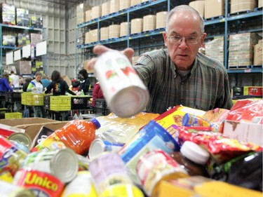 Calgary Food Bank volunteer Stan (no last name) sorted through donated food at the food bank on November 13, 2014 in preparation for distribution.