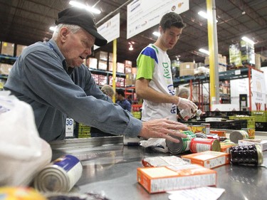 Calgary Food Bank volunteers Bob Allen, left, and Kyle Zerbin sorted through donated food at the food bank on November 13, 2014 in preparation for distribution.