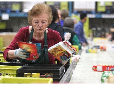 Calgary Food Bank volunteer Rita Lohues sorted through donated food at the food bank on November 13, 2014 in preparation for distribution.