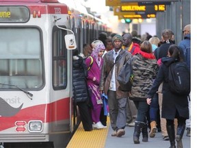 Commuters access a train at the City Hall CTrain station on Tuesday.