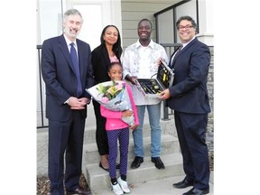 Coun. Richard Pootmans, left, and Mayor Naheed Nenshi, right, greeted Stephen Korkoya, Marie Razafiarisoa and daughter Grace. Courtesy, Attainable Homes