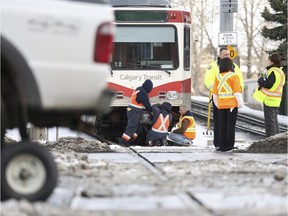 Crews work on the C-train that struck a truck while crossed the street at the intersection of 9 Street SW and 4 Avenue SW in Calgary, on November 20, 2014. --