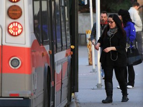 Calgary Transit buses and commuters at the Heritage LRT CTrain station.