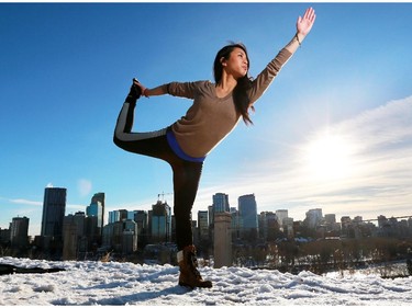 Lee Lee Kho takes advantage of the warm afternoon light and +4 C degree temperature as she does yoga along Crescent Road in Calgary on Tuesday November 18, 2014.