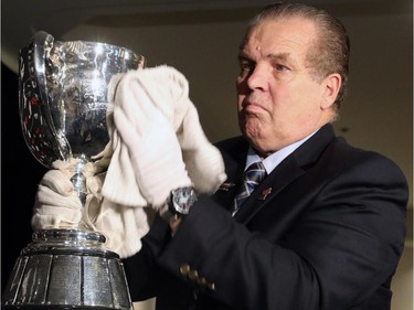 Dennis Dowell, the Grey Cup handler, polishes the cup before the Calgary Stampeders - CFL West Champions media lunch at the Hyatt Regency Hotel in Vancouver on Thursday, November 27, 2014.