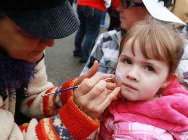 Three year-old Grace Grototts get a tiny Stampeders horse painted on her cheek at the Calgary Grey Cup Committee pancake breakfast at Canada Place in Vancouver on Thursday, November 27, 2014.