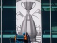 Workers install a Grey Cup sign on the outside of B.C. Place stadium in Vancouver.