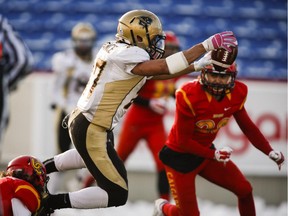 Manitoba Bisons Kienan LaFrance, left, dives in for a touchdown as Calgary Dinos Hunter Turnbull looks on during first half CIS Hardy Cup football action in Calgary, Saturday, Nov. 15, 2014.