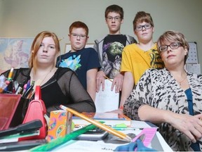 Jennifer Deuel, right, is photographed in her home, in the room that she uses as a classroom to home-school her four children, Ryleigh, 16, left, Madoc, 10, Brayden, 14, and Liam, 12. Deuel is owed $1,644 in unpaid home-schooling expenses when a Calgary private school declared bankruptcy after reassuring Alberta Education it would reimburse parents with monies paid by the government.