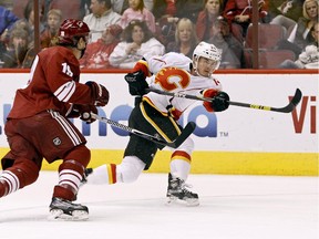 Calgary Flames' Jiri Hudler, of the Czech Republic, right, shoots the puck  as Arizona Coyotes' Shane Doan defends during the third period of an NHL game Saturday, Nov. 29, 2014 in Glendale, Ariz. Hudler had a goal in the Flames 3-0 victory over the Coyotes.