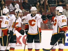 Calgary Flames' Johnny Gaudreau (13), T.J. Brodie, center left, Mark Giordano (5) and Josh Jooris (86) celebrate Brodie's second period goal against the Arizona Coyotes during an NHL game Saturday, Nov. 29, 2014 in Glendale, Ariz.