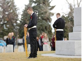 Juno Beach Academy student honour guard during the No Stone Left Alone ceremony where Canadian Forces soldiers and students place poppies on all military graves at Burnsland Cemetery in Calgary on Thursday.