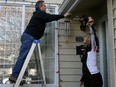 File — Stringing up Christmas lights at a Calgary home.