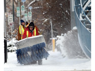 Thomas Resch pushes a large snowblower and Jacob Messom carries a shovelwhile cleaning sidewalks in Kensington on Monday, November 10, 2014.