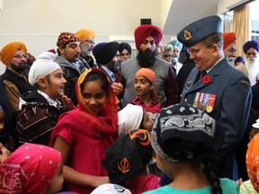 Sikh children surround Dean Gray, unit personnel selection officer from the Canadian Forces recruiting centre from Prairies and the North, at the Desmesh Cultural Centre in Calgary on November 16, 2014. The Canadian military joined the Sikh community for the first time in a special Remembrance Day Ceremony to remember Canada's fallen men and women who have served our nation.